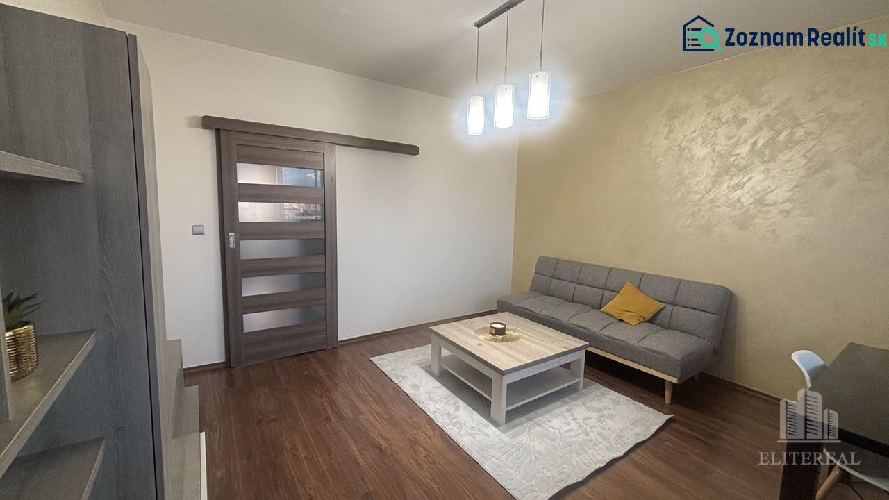 Living room in a 3-room apartment with a sofa, table, and floor with wooden decor.