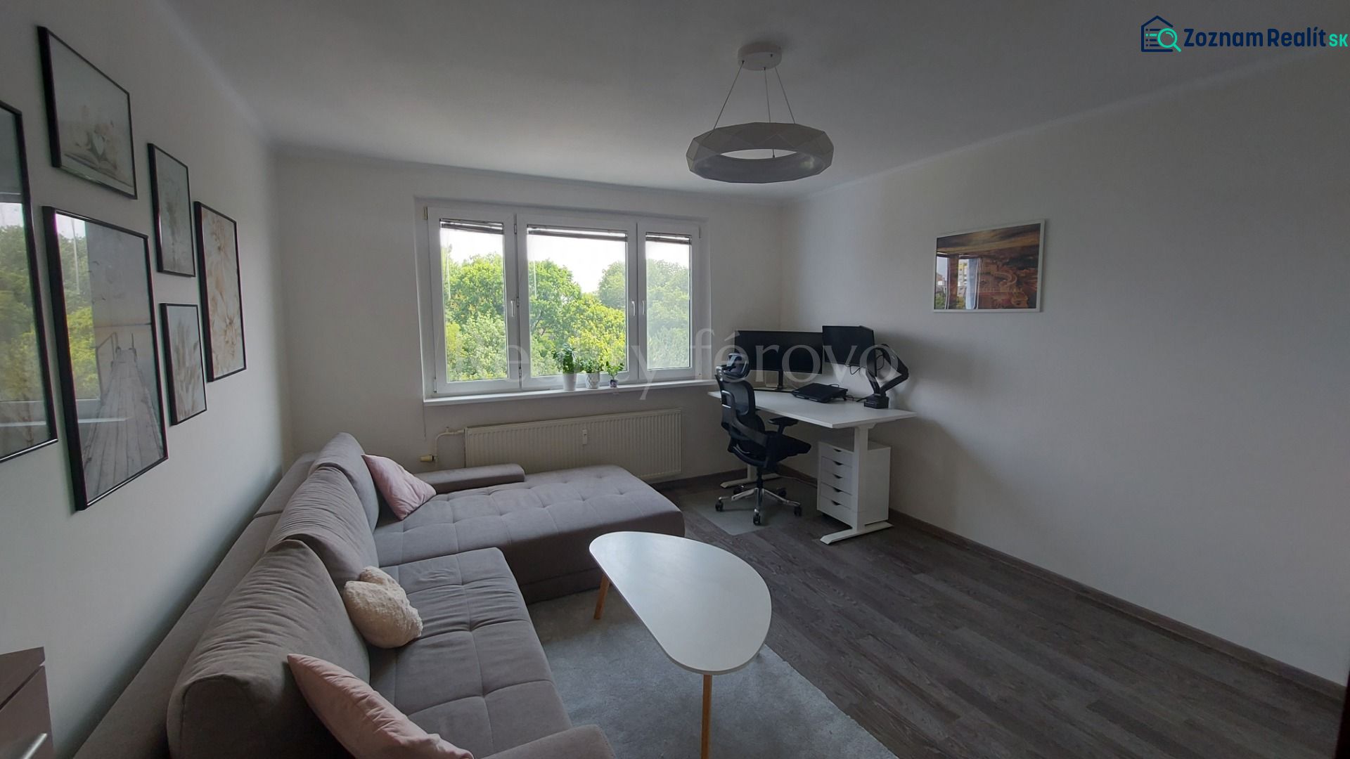 Living room in a two-room apartment with a corner sofa, a coffee table, and a desk.