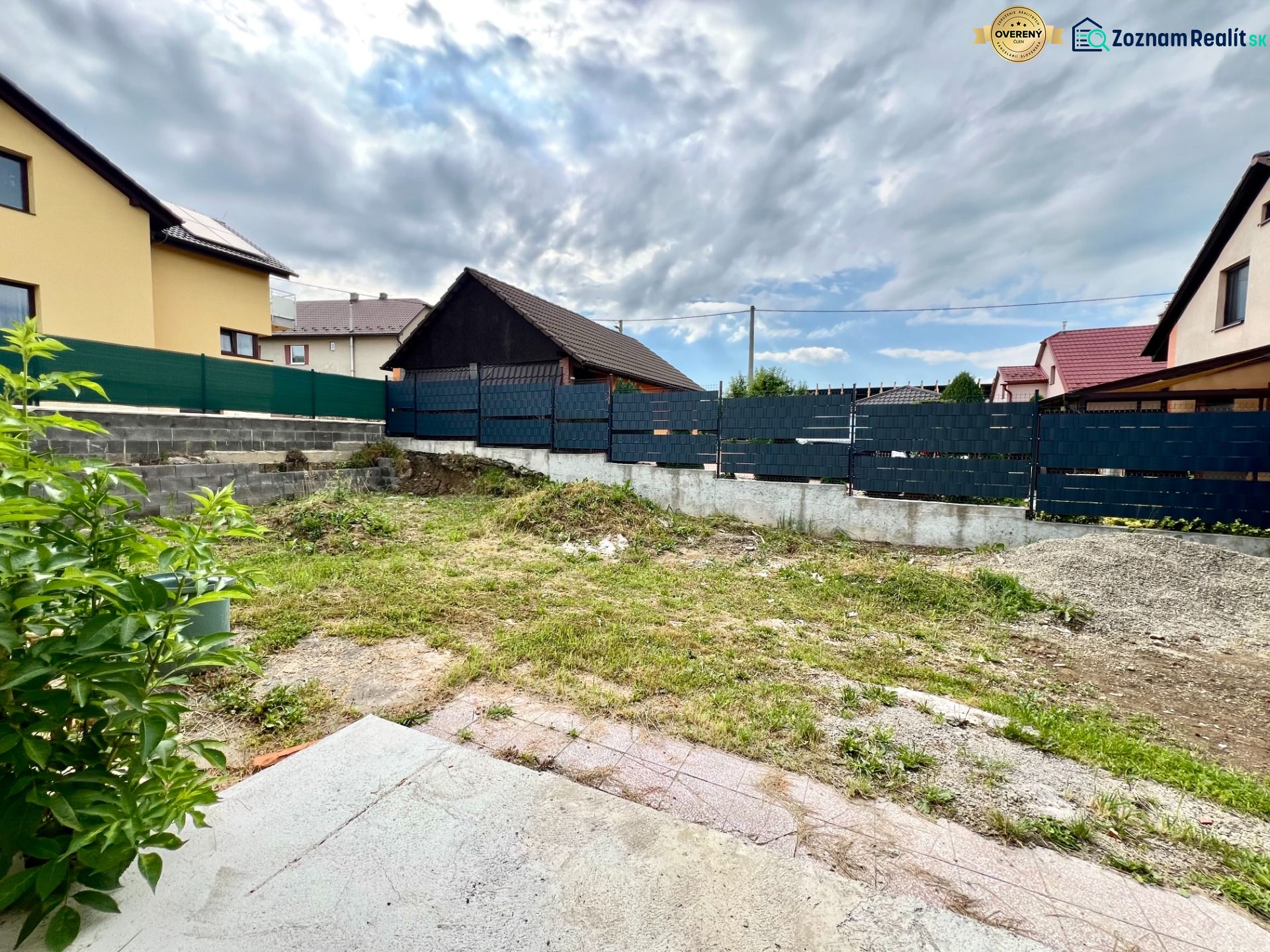 A family house in Ľubotín with a fenced plot, grassy area, and neighboring houses.