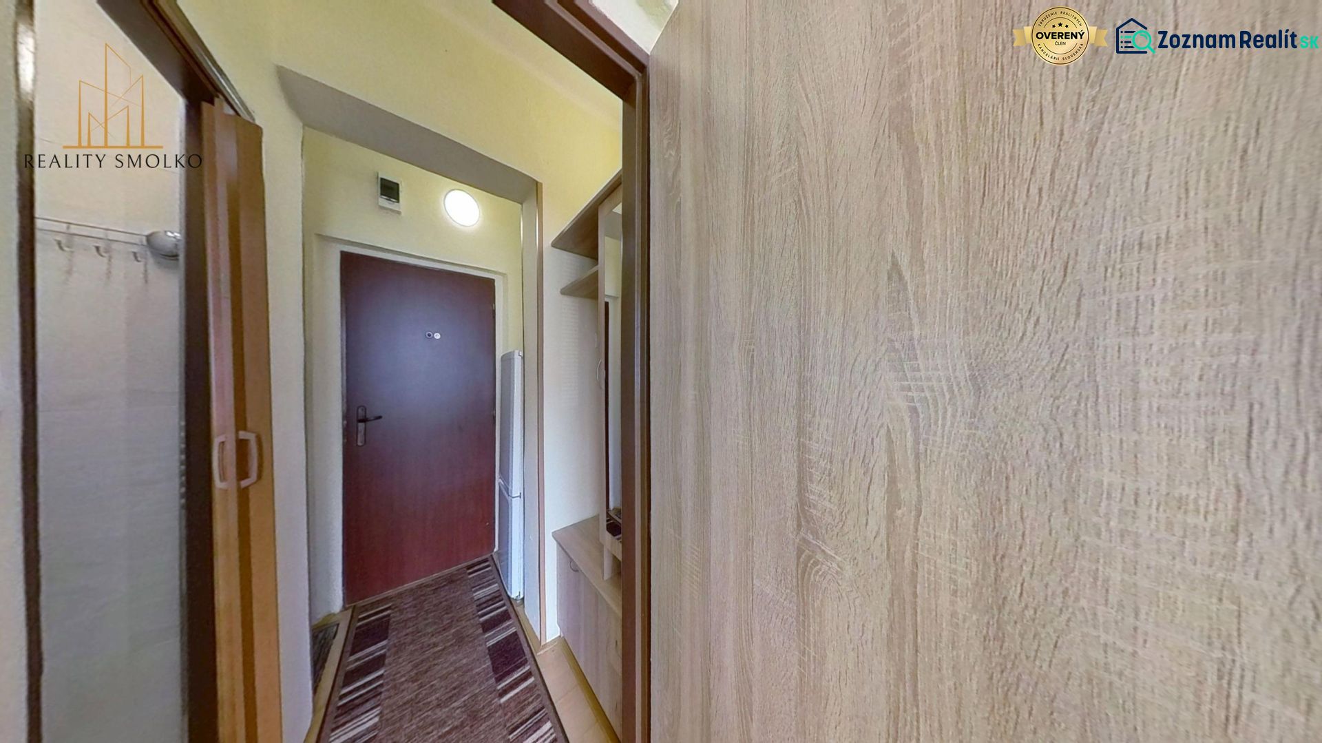 Hallway of a recreational apartment with doors, built-in wardrobes, and a wooden decor floor.