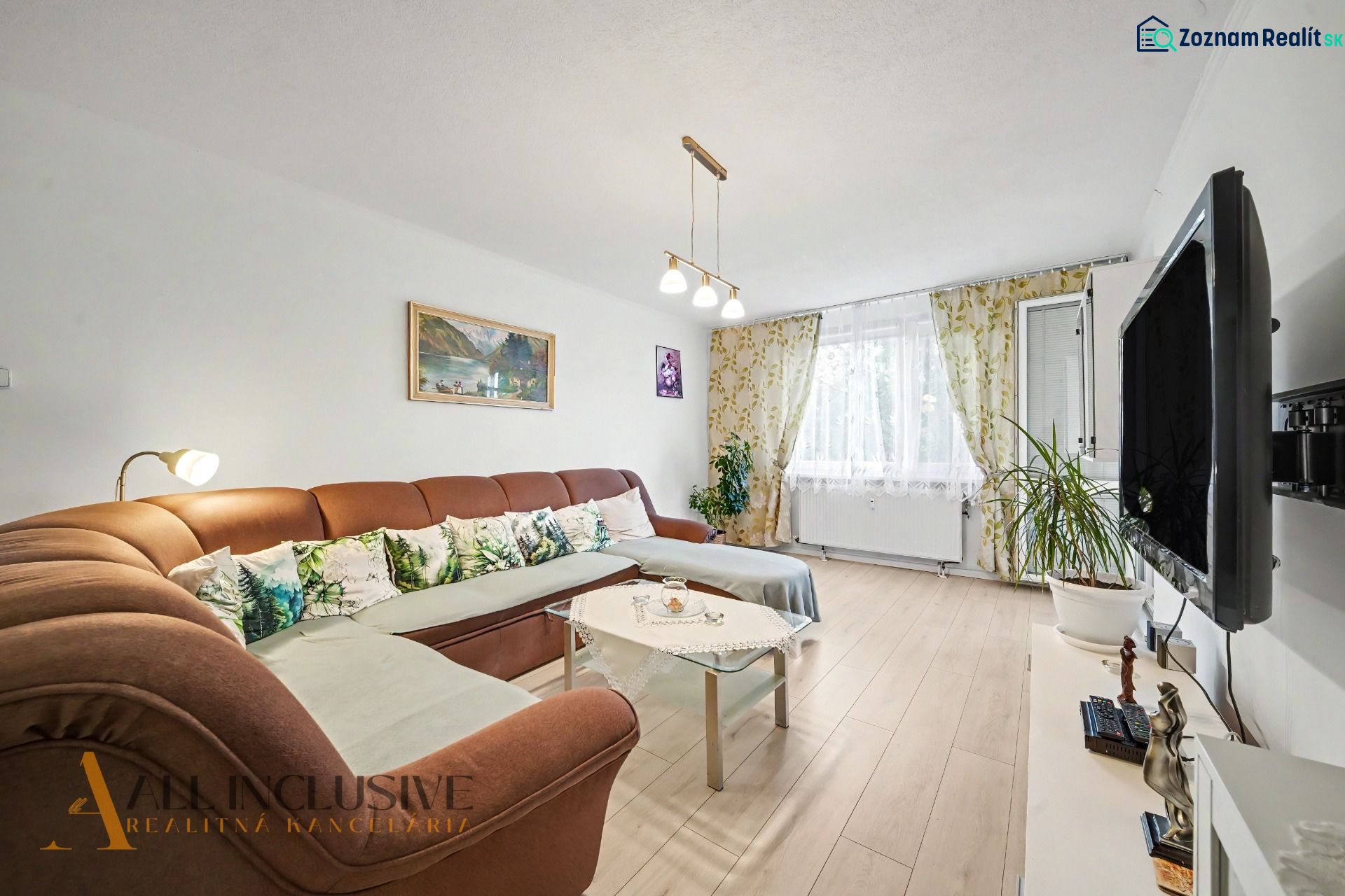 Living room in a 3-room apartment with a comfortable sofa and a television, floor with a wooden decor.