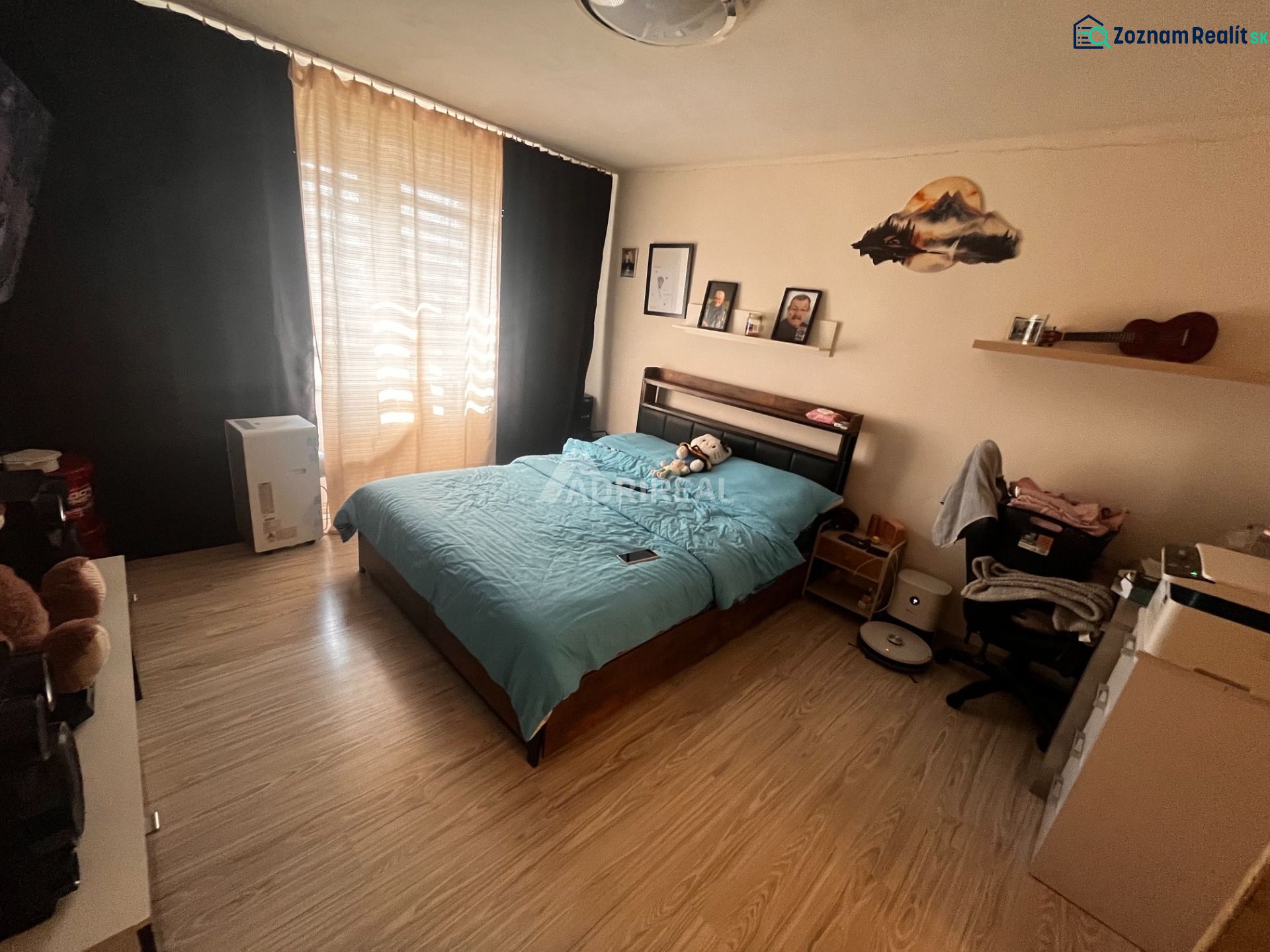 A bedroom with a bed and a wooden decor floor in a two-room apartment.
