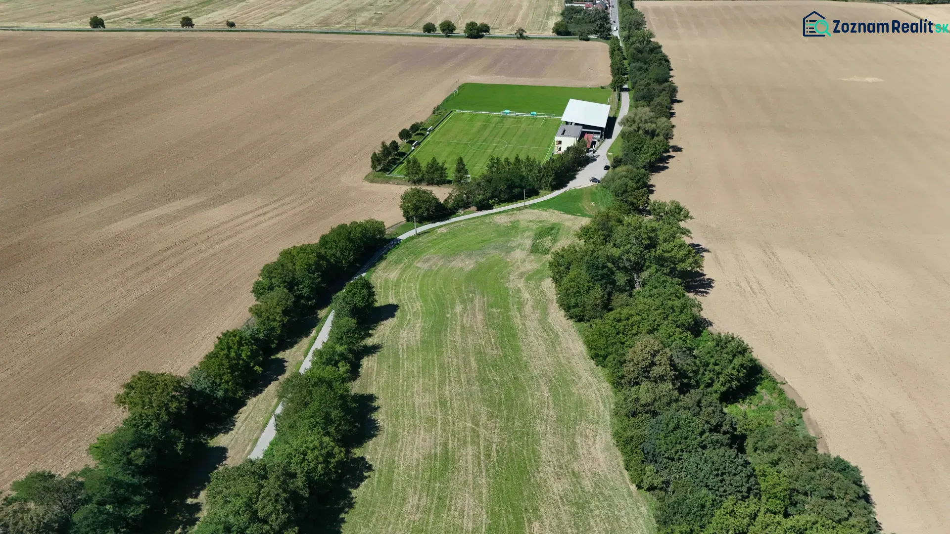 Agricultural and forest land in Nová Ves nad Váhom with a playground and a dirt road.