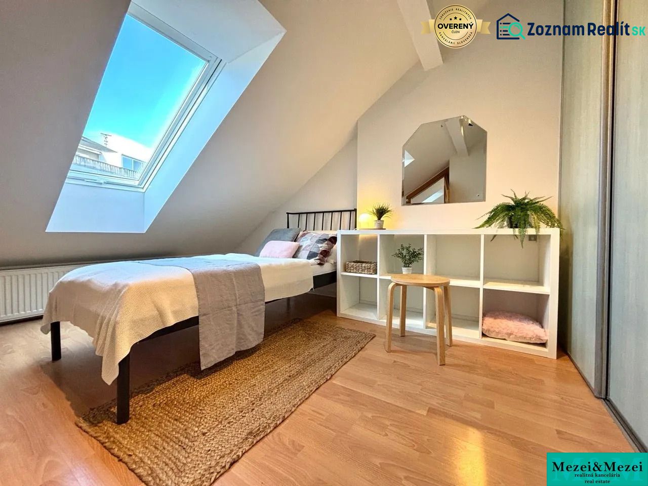 Attic room with a skylight, bed, and shelving cabinet, floor with wooden decor.