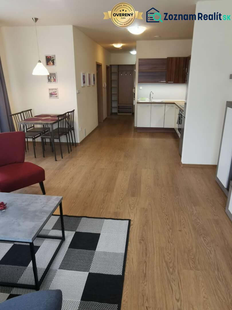 Living room with a kitchenette and wooden decor flooring in a family house.