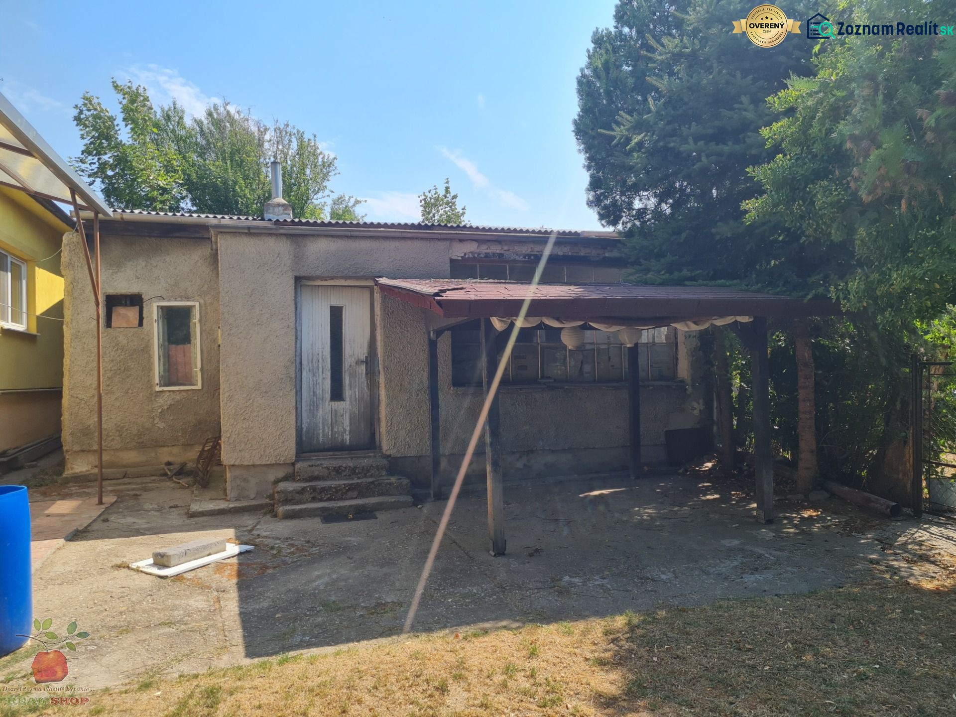 A family house in Komjatice with a neglected outdoor area and a shelter.