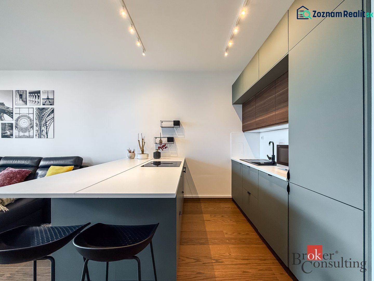 A kitchen in a 2-room apartment with a wooden decor floor, modern seating, and minimalist design.