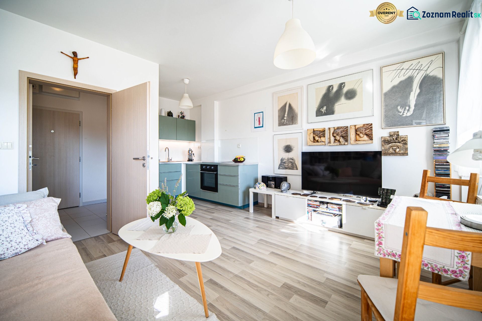 Living room in a 2-room apartment with decorative paintings and a wooden decor floor.