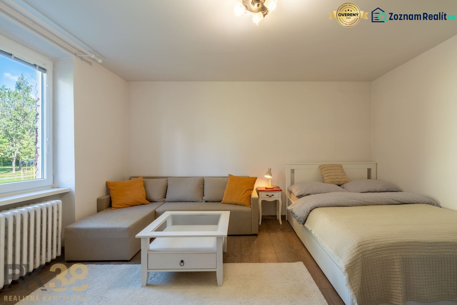 1-bedroom apartment with a sofa, bed, and wooden decor flooring.