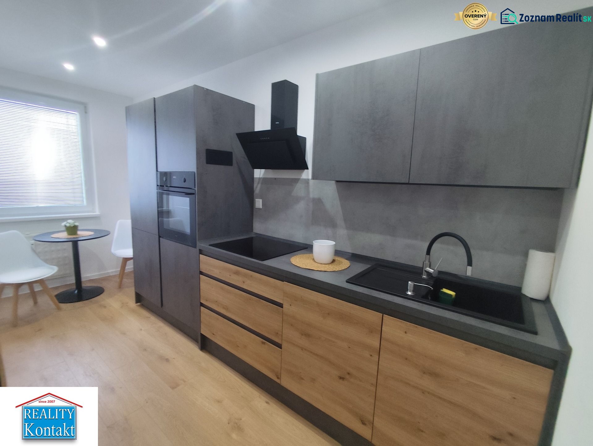 A kitchen in a 3-room apartment with a wooden decor floor and stylish seating.