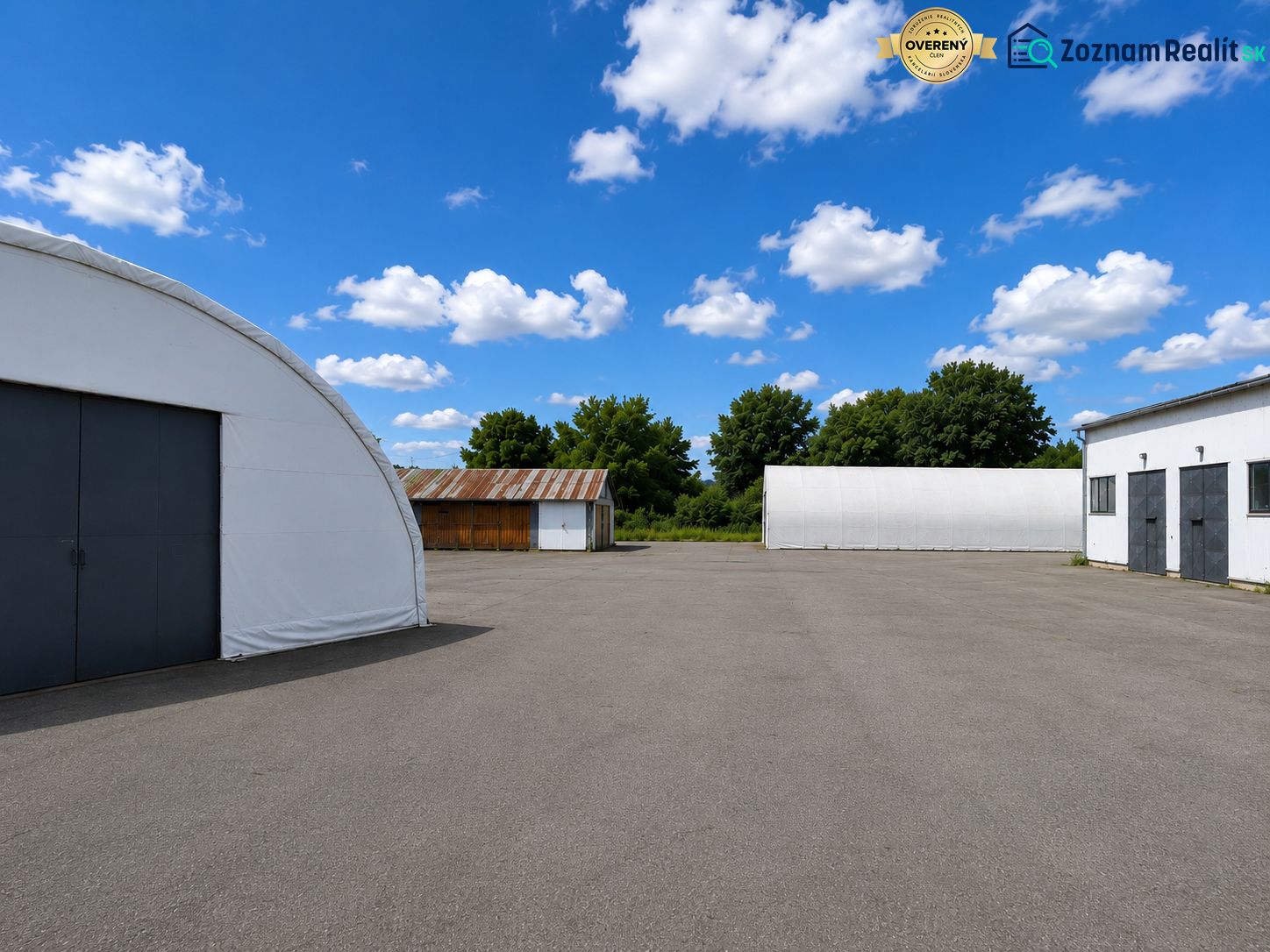 Warehouses and halls in Ličartovce with open space and blue sky.