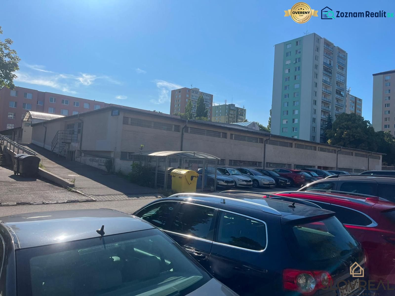 Garages on Púpavová Street in Bratislava - Karlova Ves with a parking lot and apartment buildings.