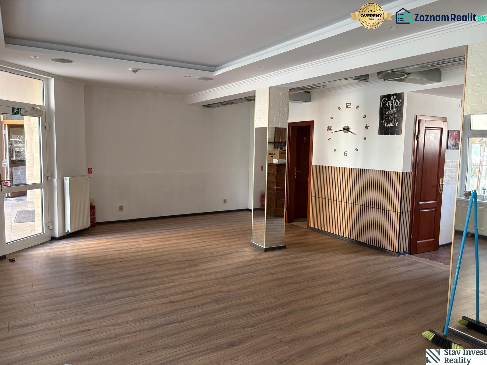 Commercial space with a wood-patterned floor and decorative clock on the wall.