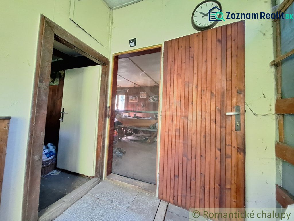 The interior of the cabin features wooden doors, a clock, and a tiled floor.