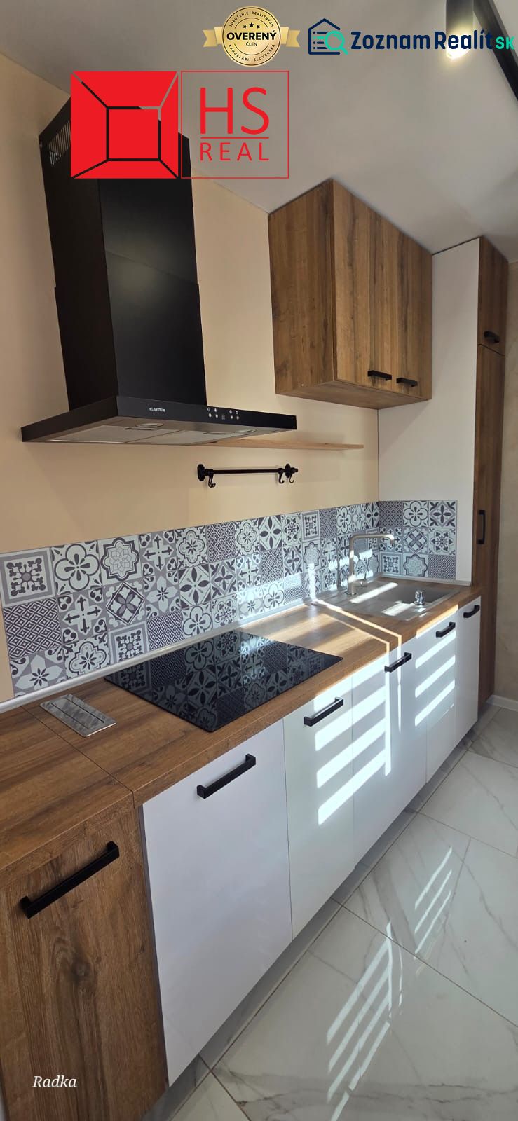 A kitchen with white cabinets, a wooden decor floor, decorative tiles.