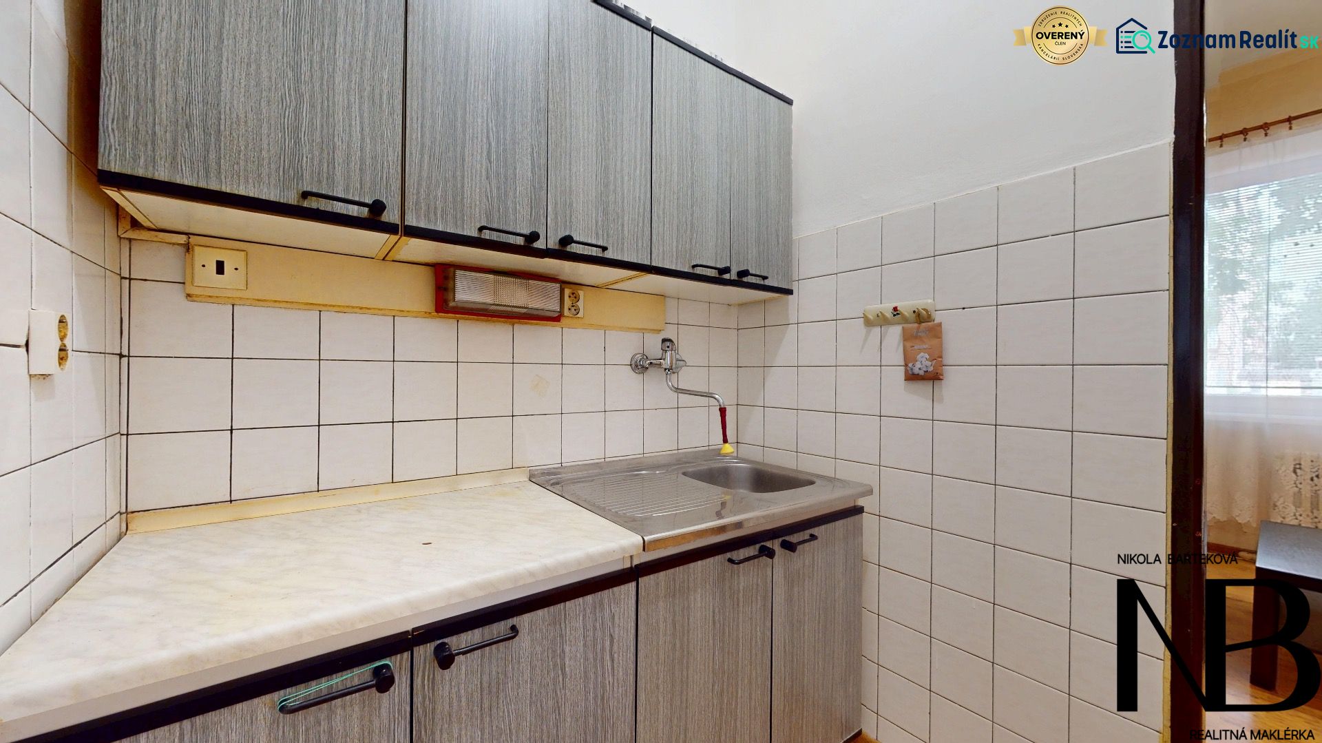 A kitchen unit with upper cabinets and a simple sink in a studio apartment.