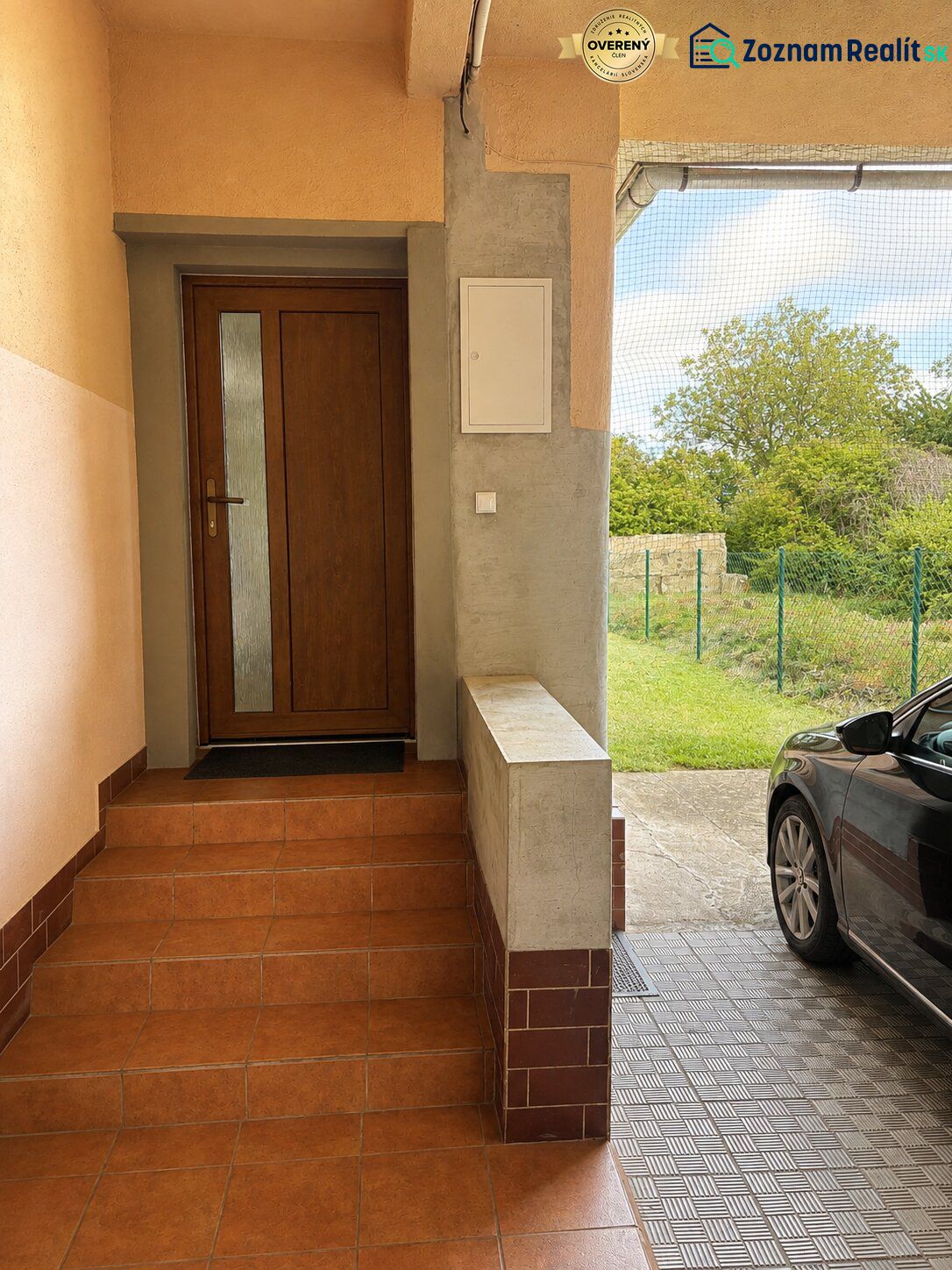 The entrance staircase of a family house on Gardom Street in Veľký Šariš, with a parked car next to it.