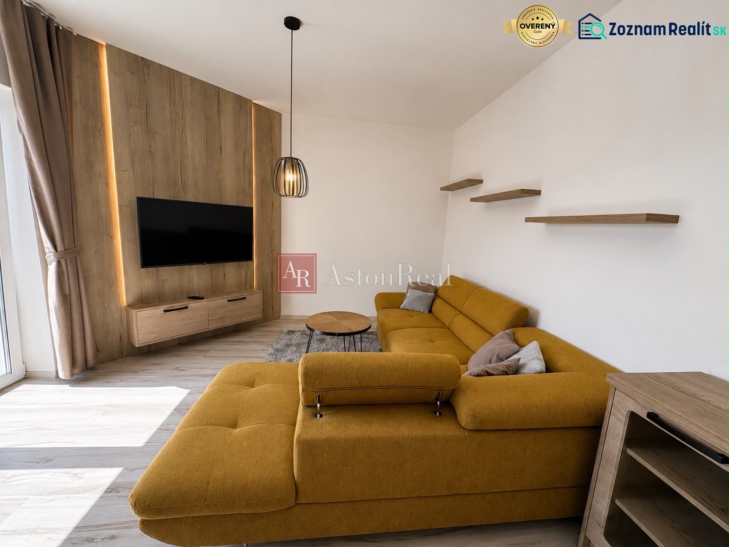 Living room with a mustard sofa, television, and wooden decor flooring.