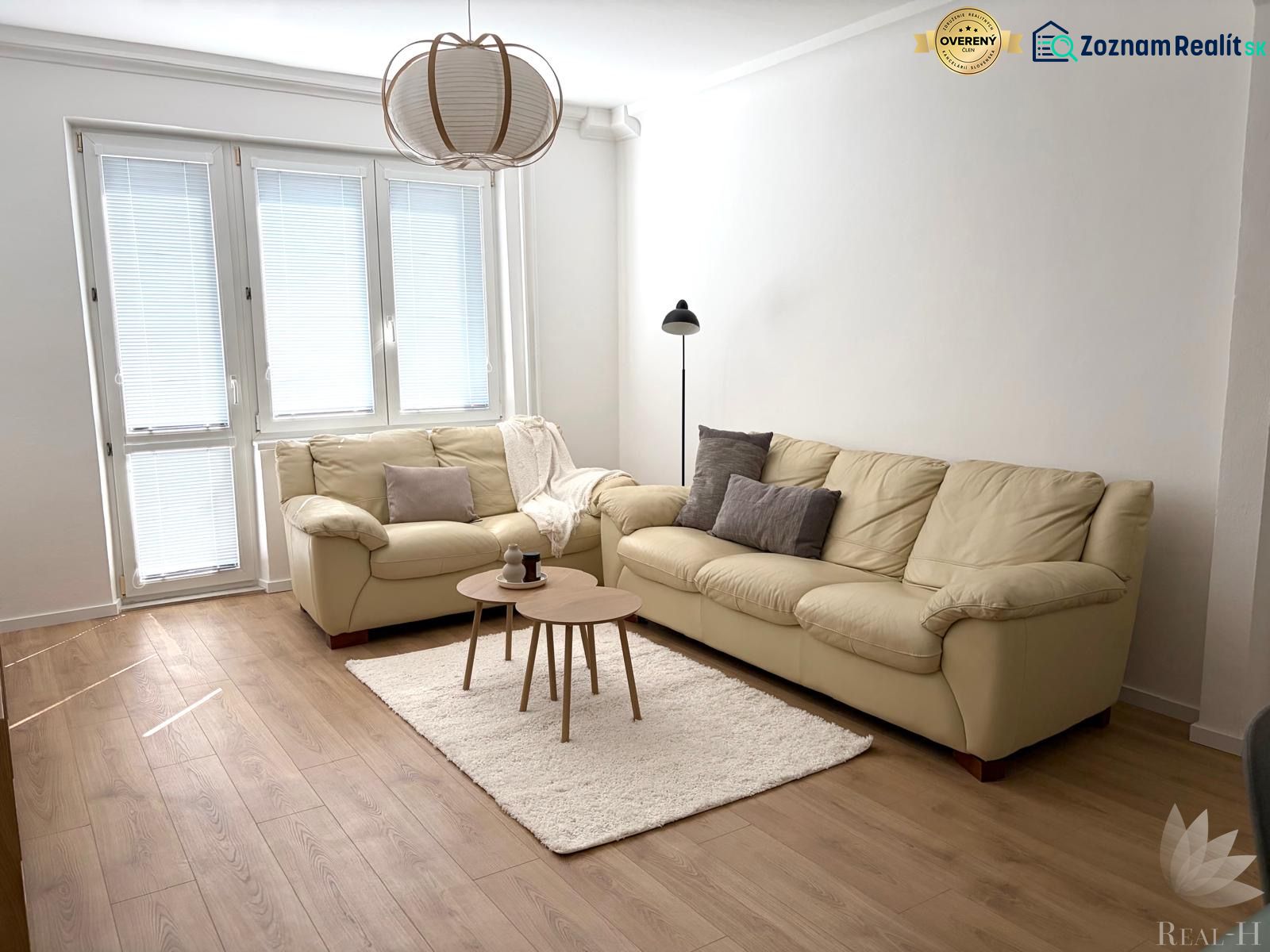 Living room in a 3-room apartment with light furniture and a wooden decor floor.
