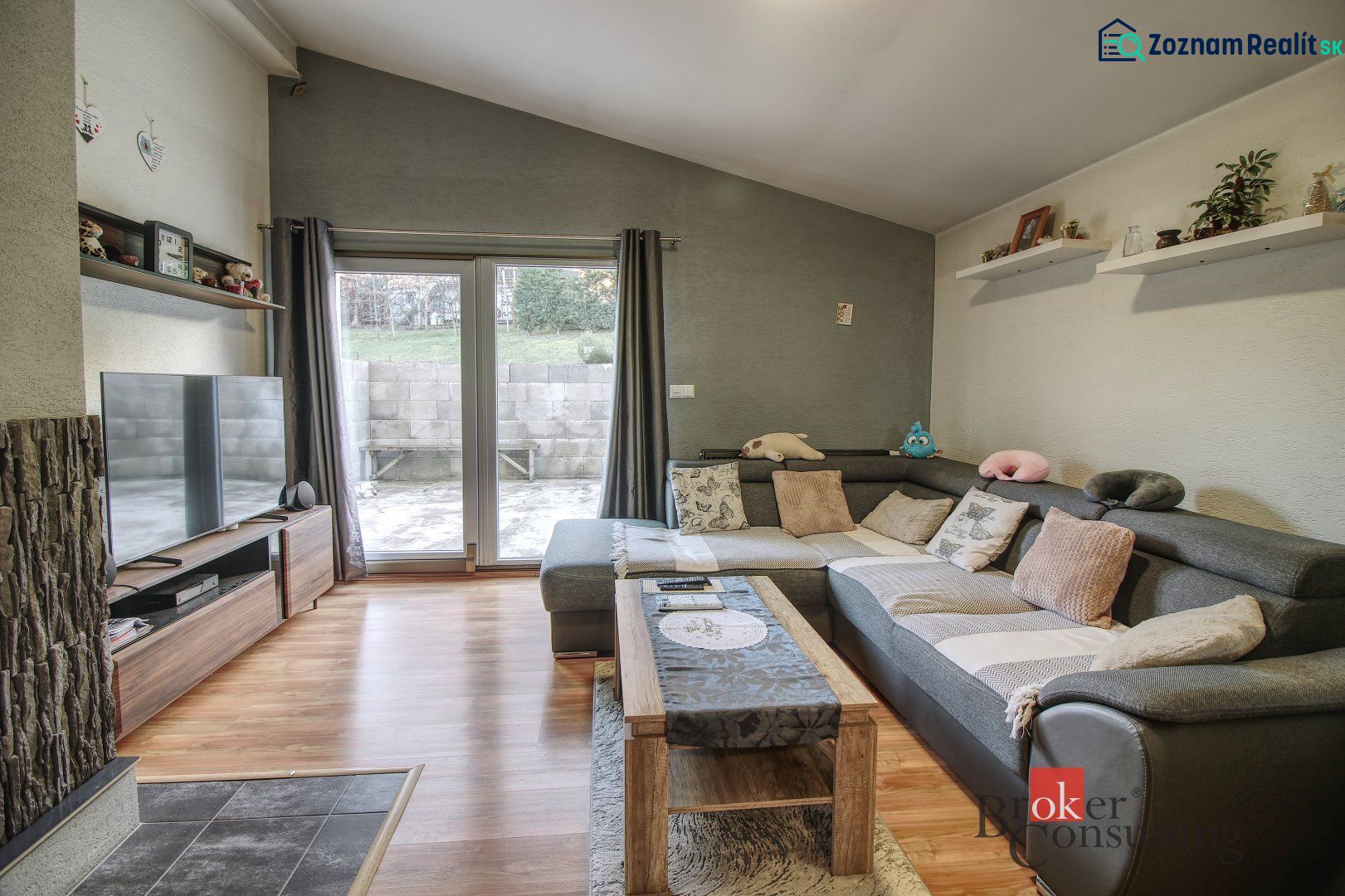Living room in a family house with a corner sofa and a wooden decor floor.