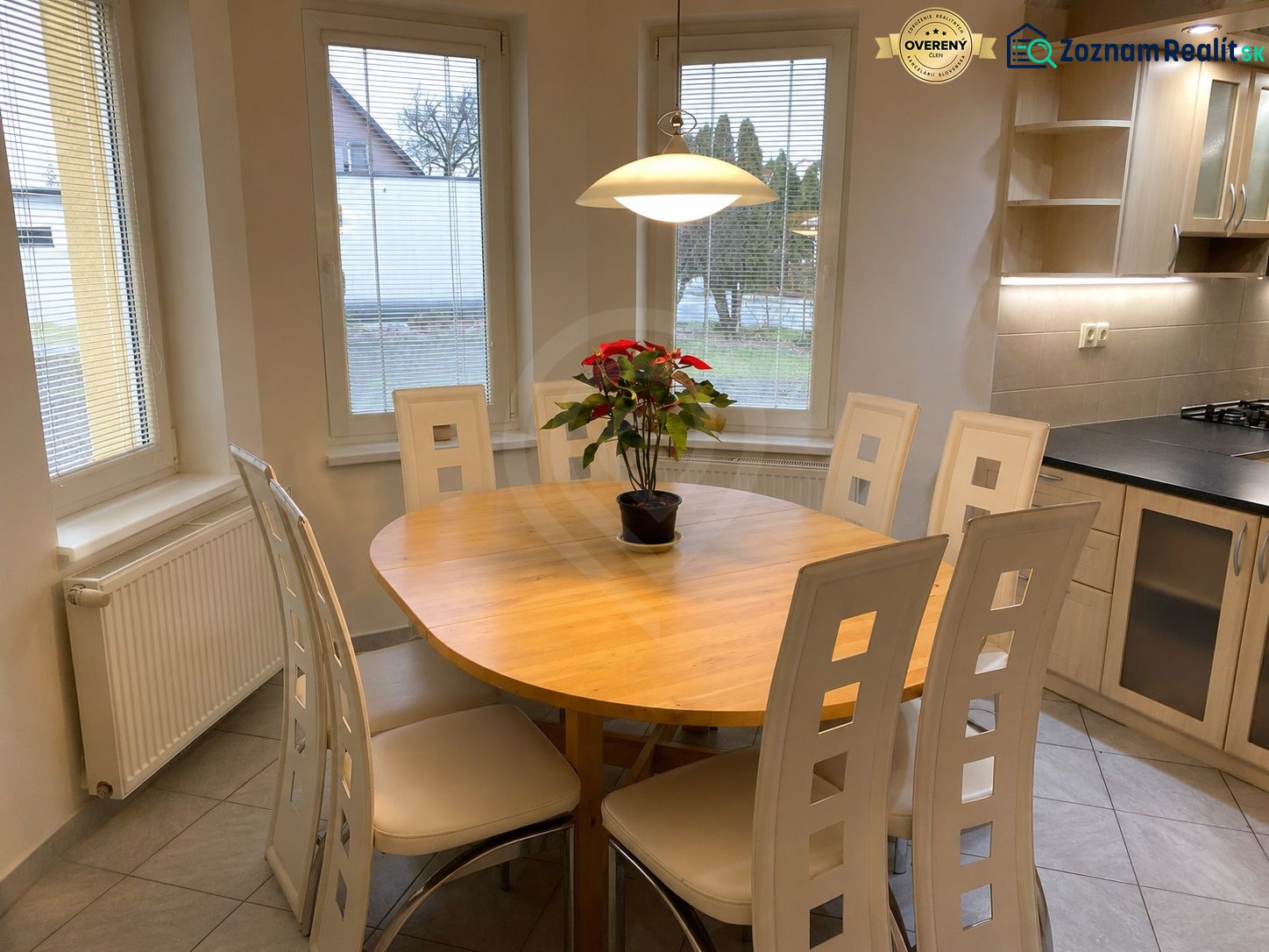 Dining area in a family house with a table, chairs, and a flower on the table.