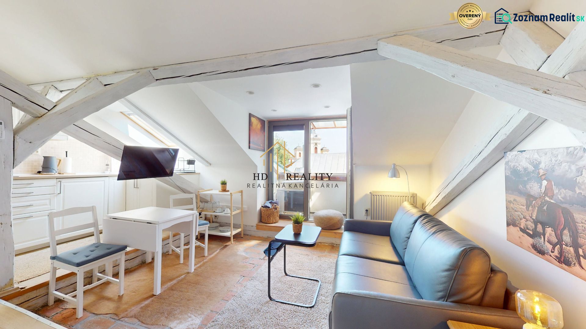 Stylish attic one-room apartment with a kitchen, white beams, and a living room.