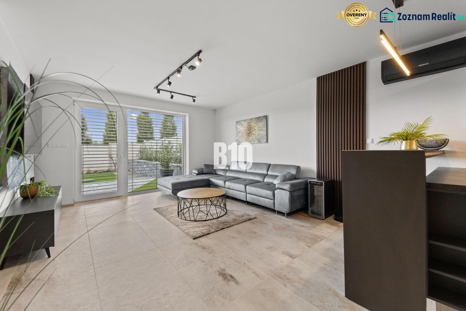 Living room with a leather sofa and windows to the terrace in a family house.