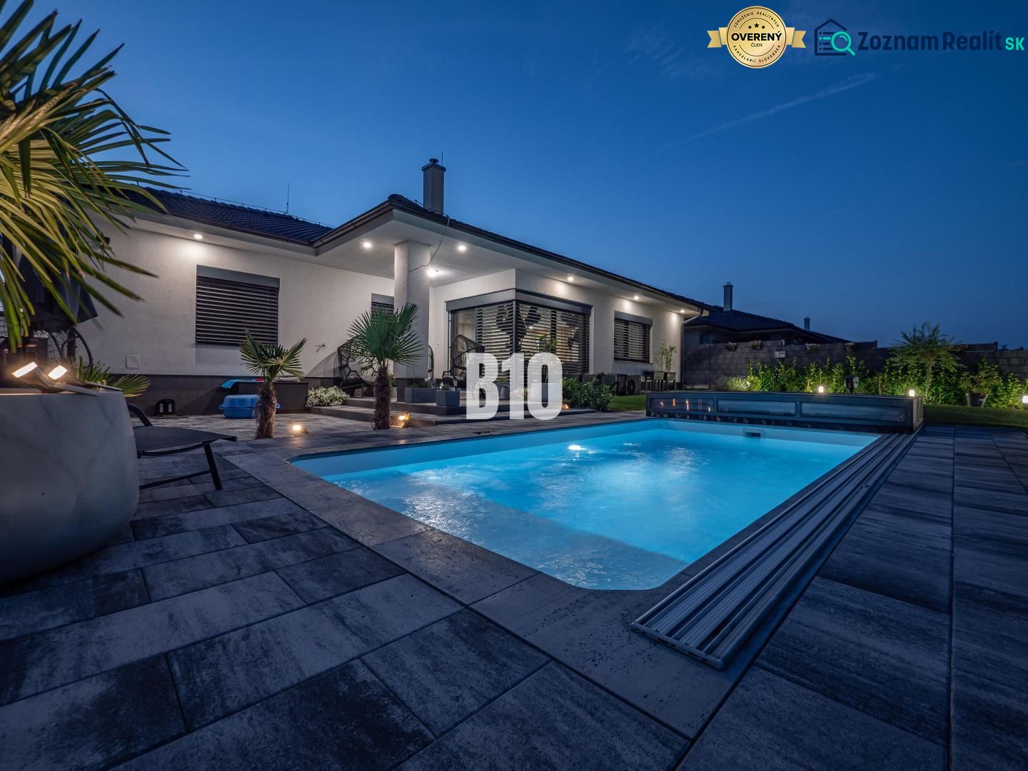 A family house in Nitra with a swimming pool and garden seating in an evening atmosphere.
