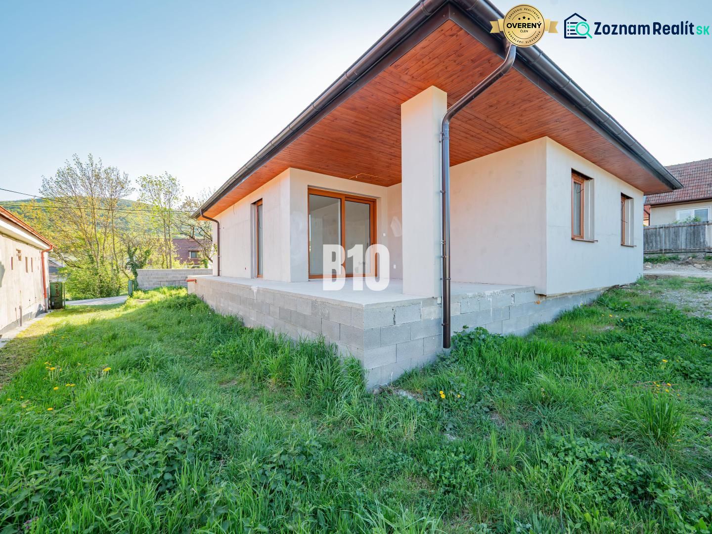 A family house in Nitra with a concrete terrace and a green lawn in the garden.