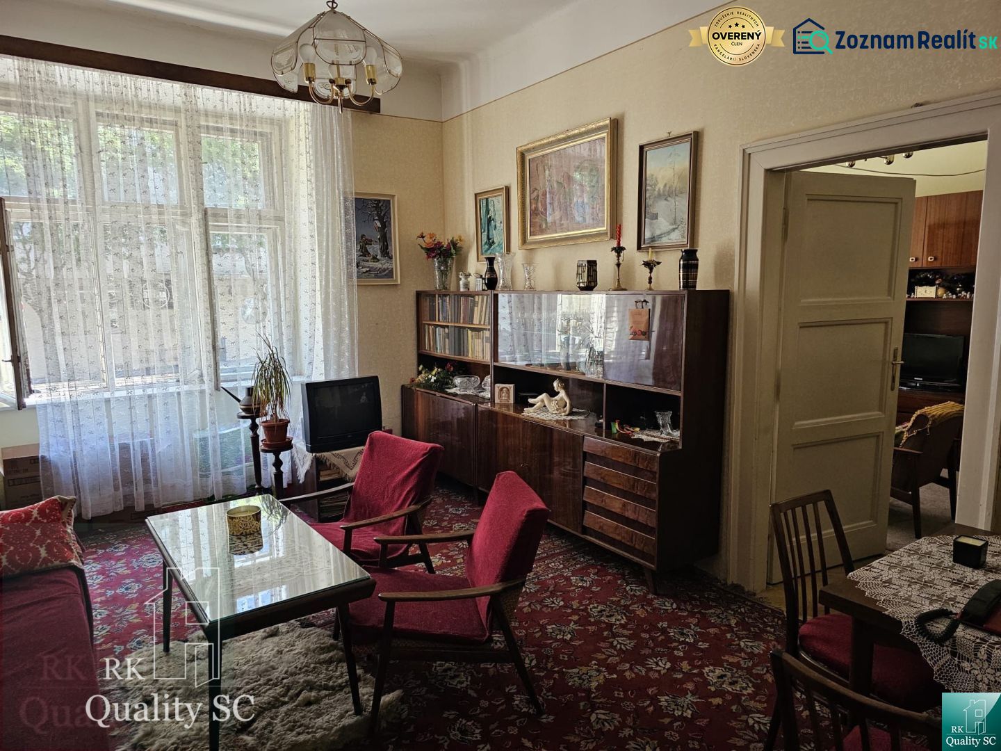 Living room in a two-room apartment with retro furniture and red armchairs.