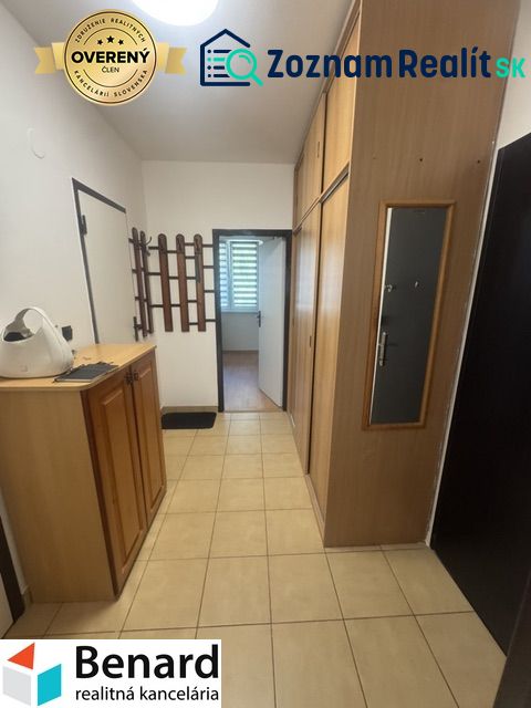 A hallway with storage cabinets and tiles in a 2-room apartment.
