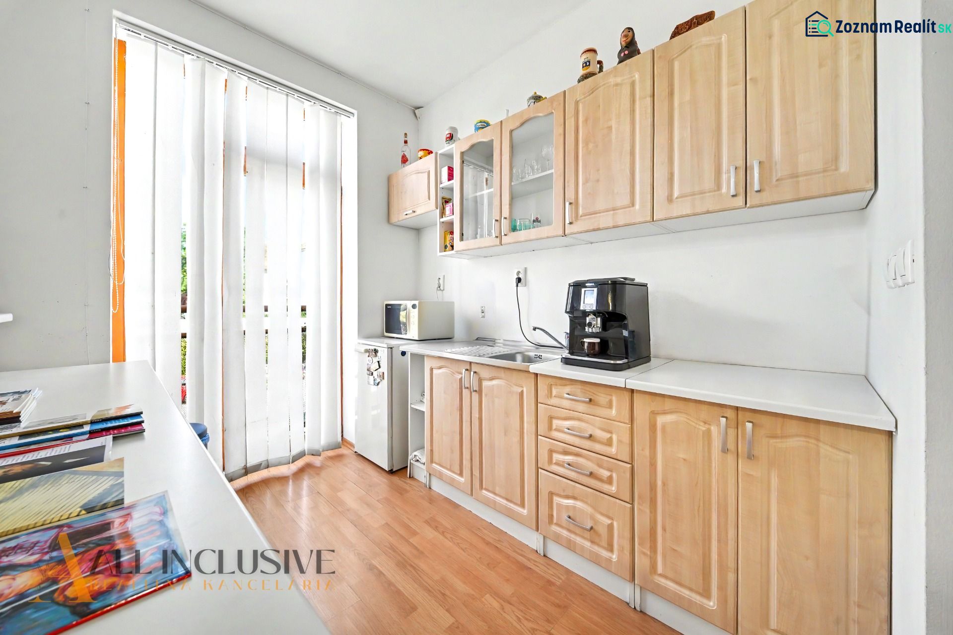 A kitchen with a wooden decor floor and appliances in a 3-room apartment.