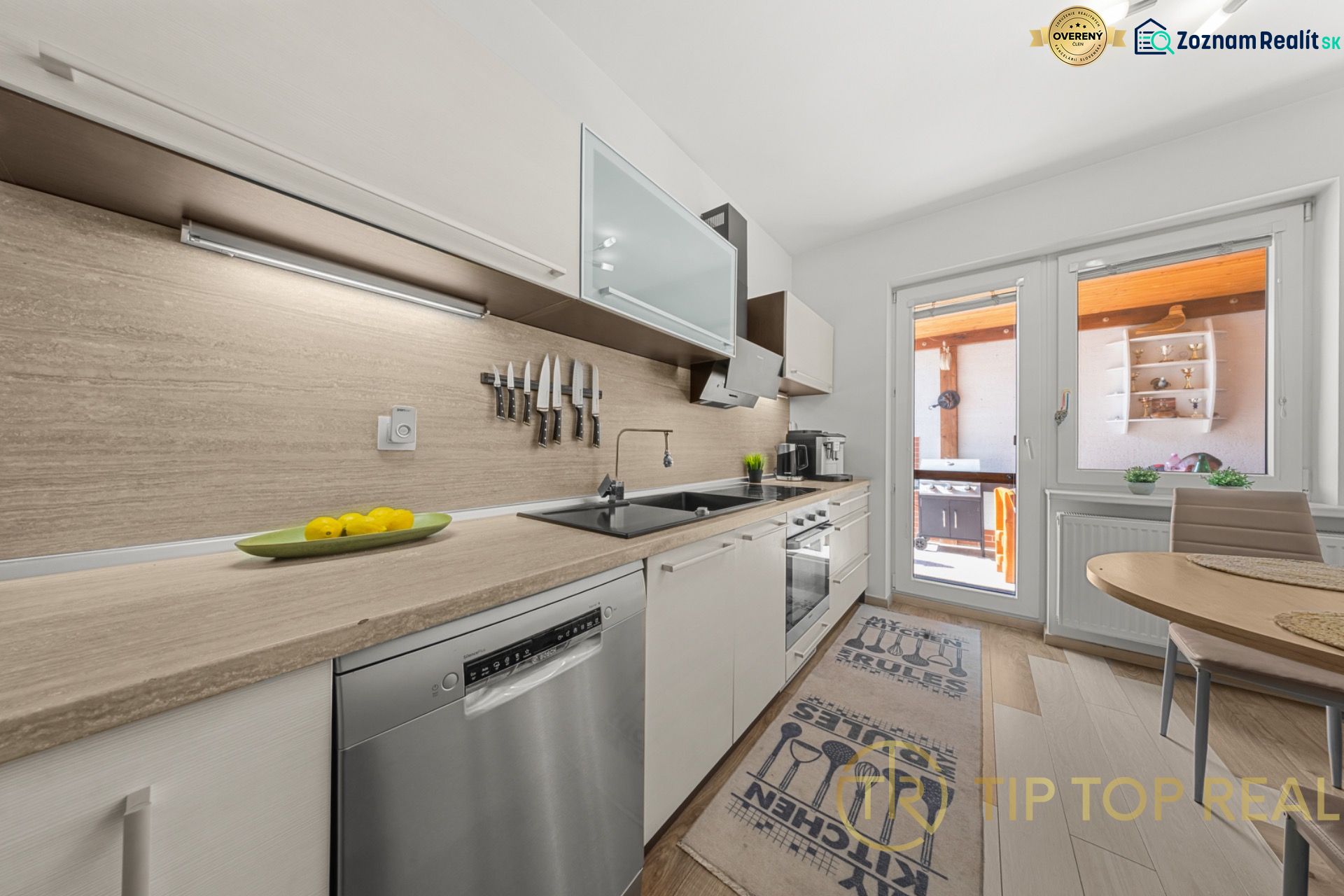 Family house kitchen with kitchen unit, dining table, and decorative plants.