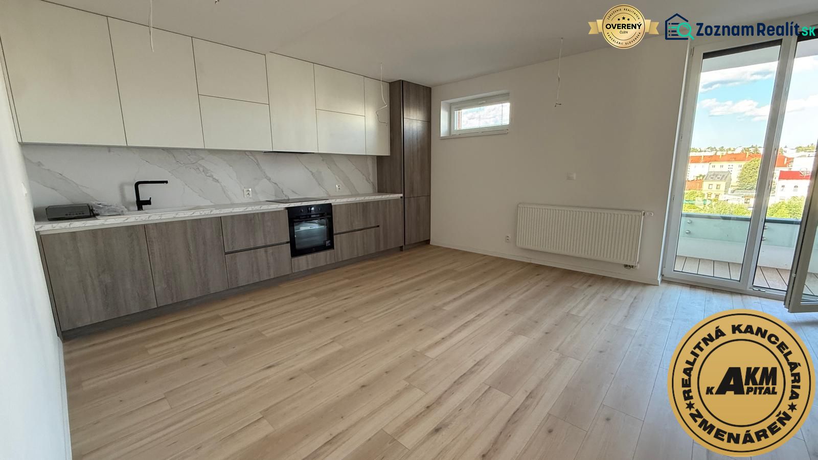 A kitchen in a 3-room apartment with a wooden decor floor and a balcony.