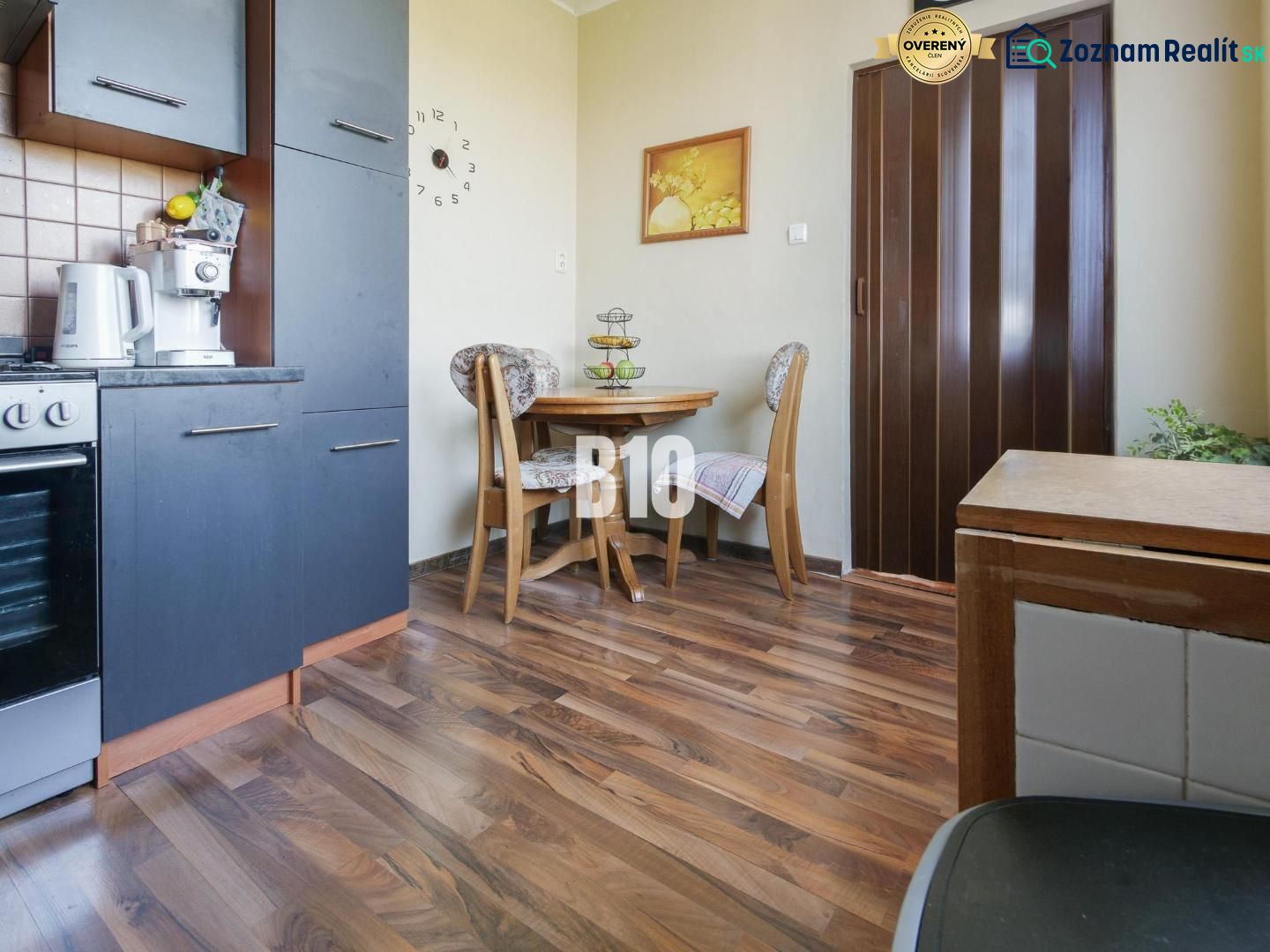 A kitchen corner in a 2-room apartment with a wooden decor floor and a dining table.