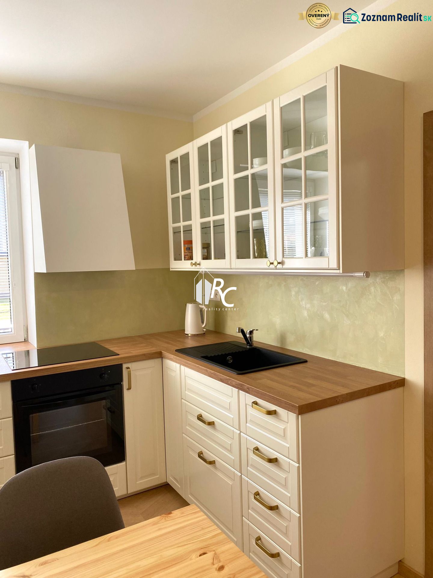 A kitchen in a 3-room apartment with white cabinets and a wood-patterned floor.