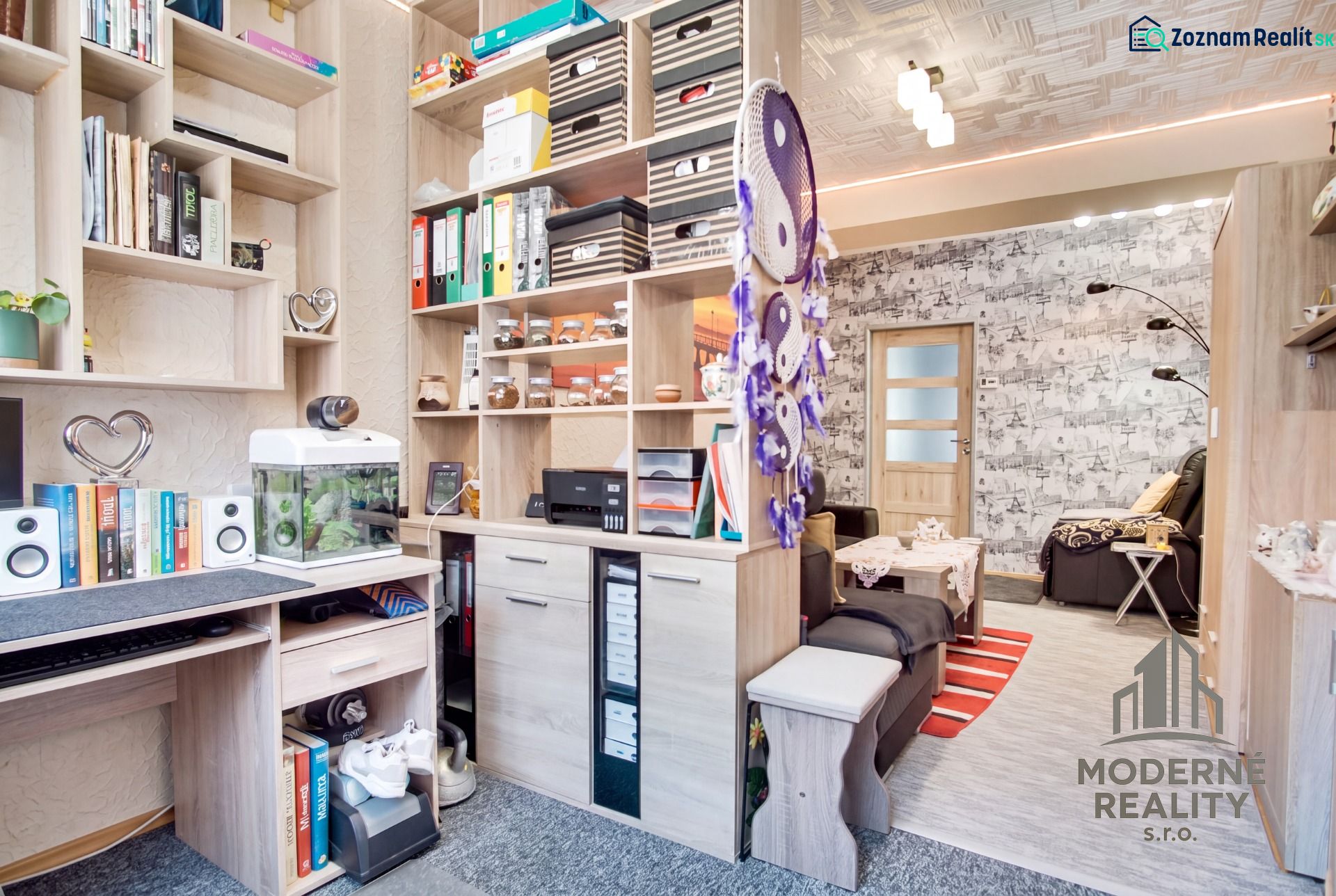 A workspace and living room in a 2-room apartment with shelves and decorations.