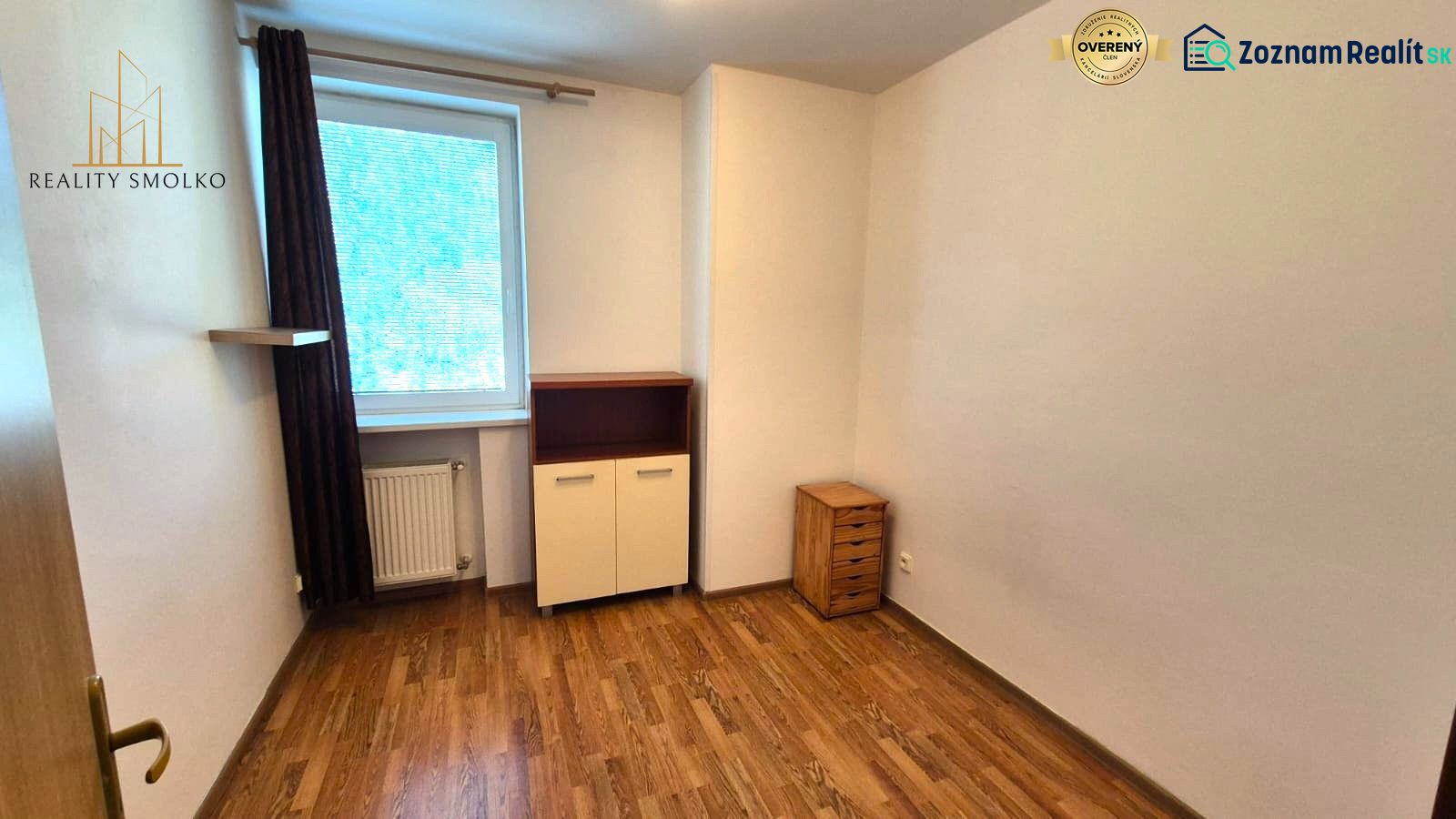 A room with a wooden decor floor in a studio apartment with light furniture.