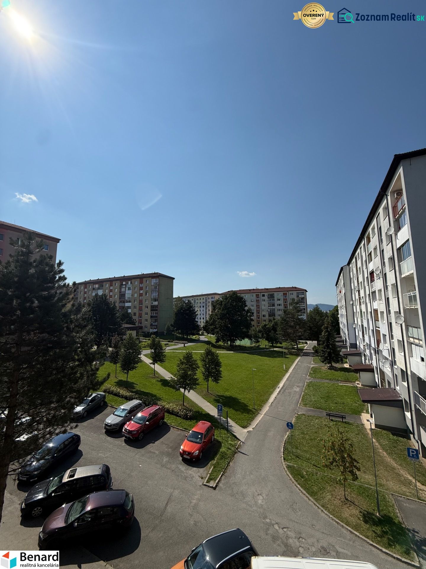 A view of the housing estate with a parking lot, trees, and apartment buildings on Mierová Street in Stará Ľubovňa.