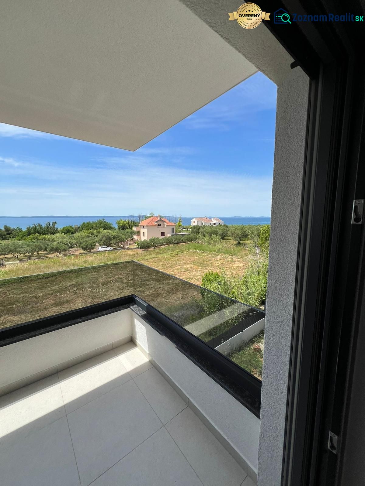 A balcony with a view of greenery and the sea in a 3-room apartment in Privlaka.