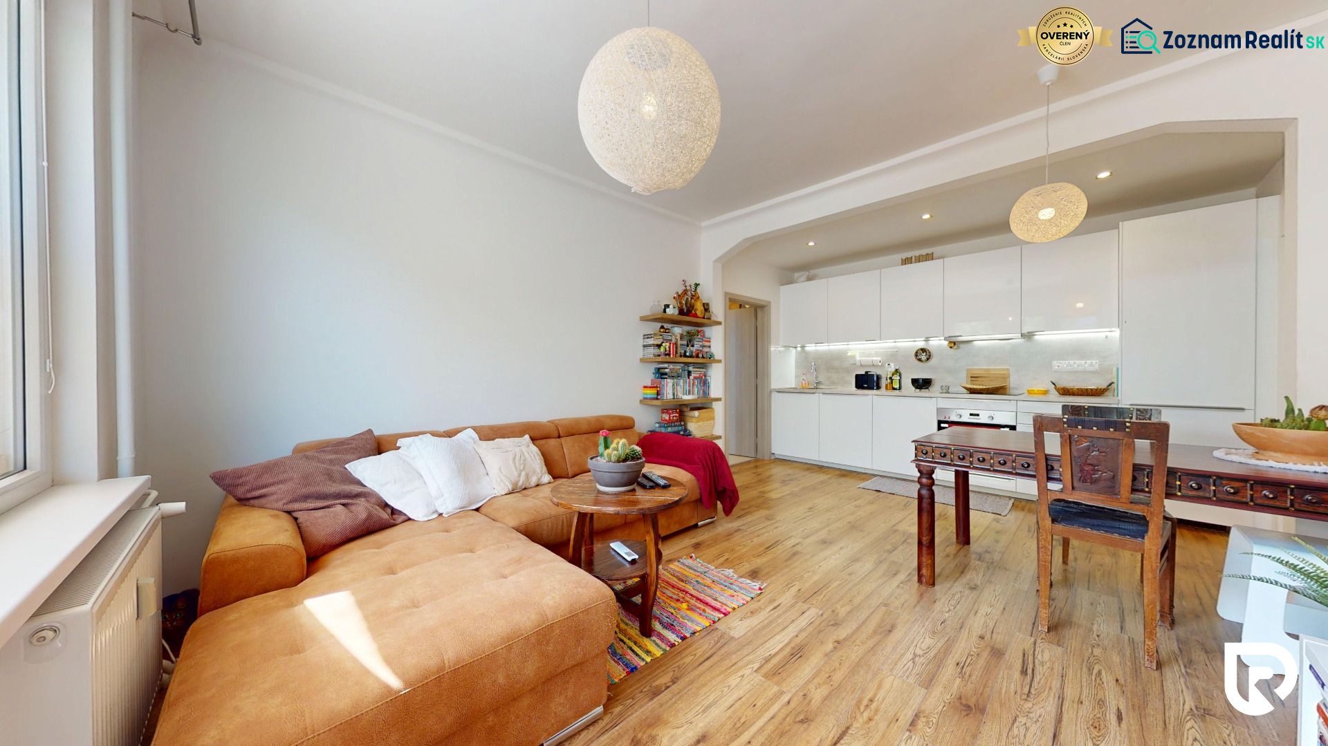 Living room with kitchen in a three-room apartment with a wooden decor floor.