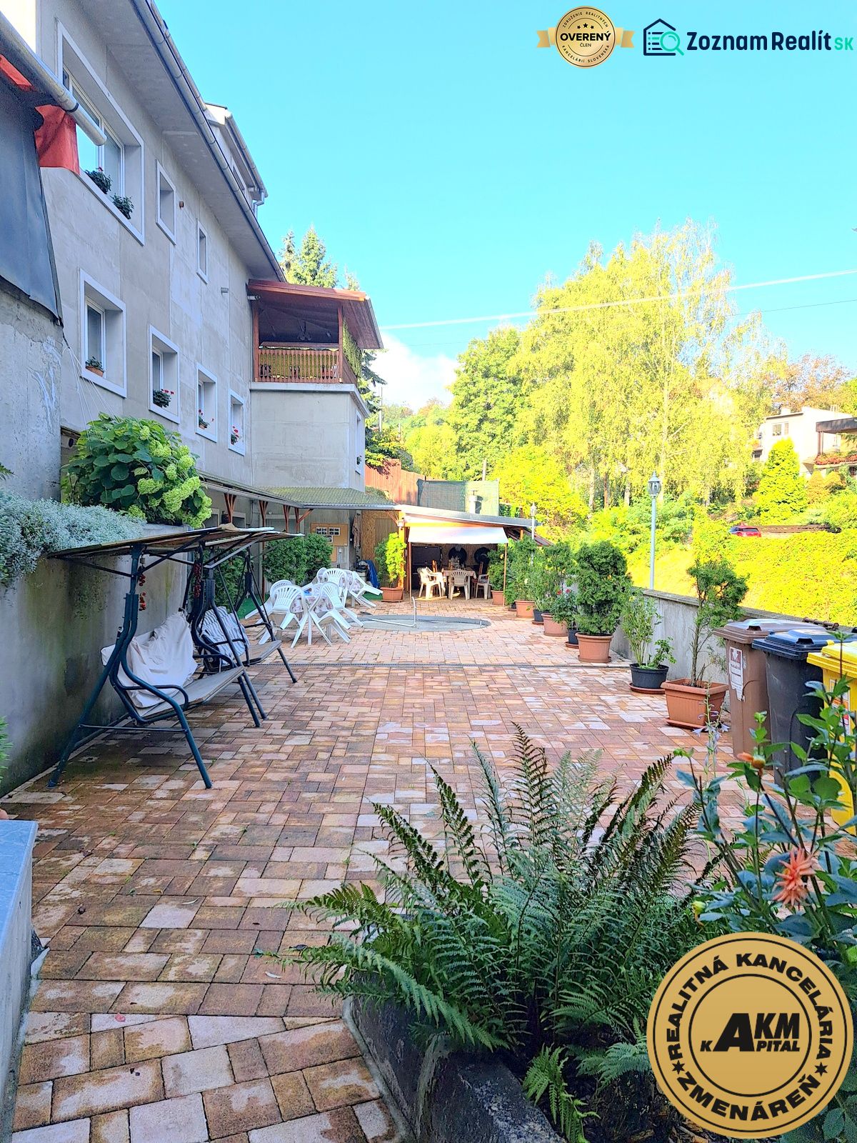 A family house in Zvolen with a paved courtyard and a garden seating area.