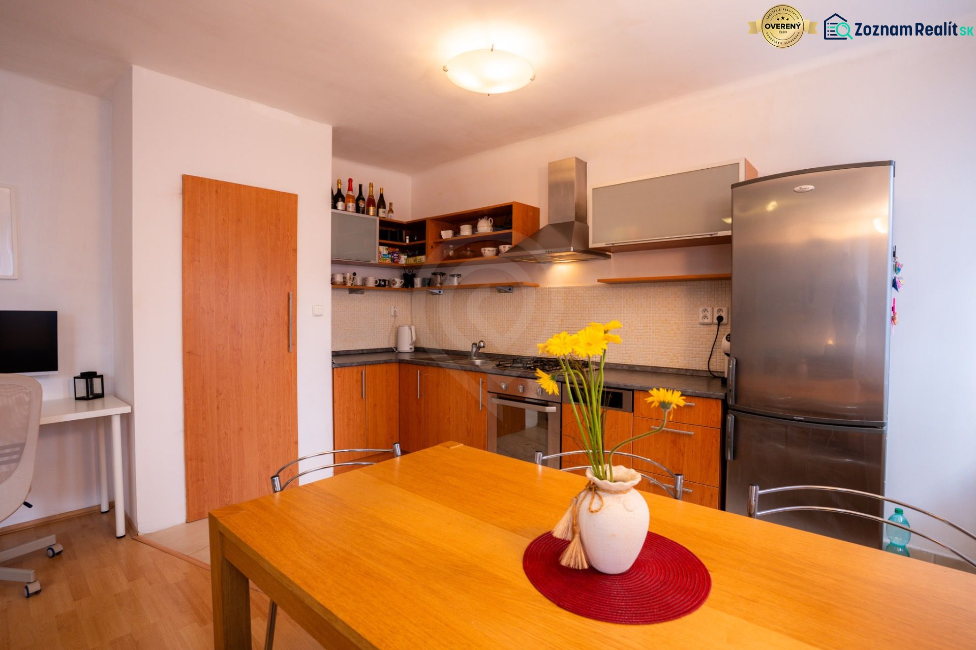 A kitchen in a 4-room apartment with a wooden decor and a yellow floral accessory.