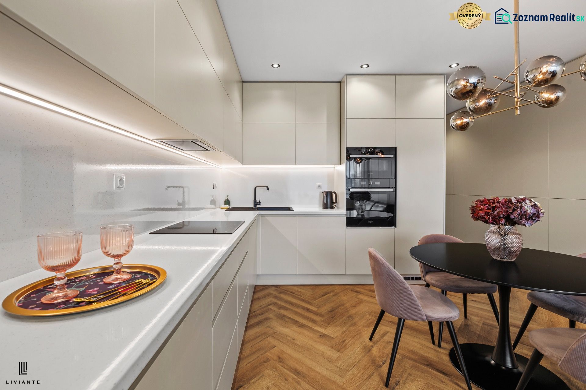 A kitchen in a 3-room apartment with a wood-patterned floor and elegant lighting.