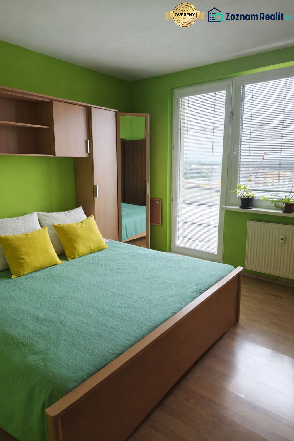 Green bedroom with a bed and a wardrobe in a wooden decor in a 3-room apartment.