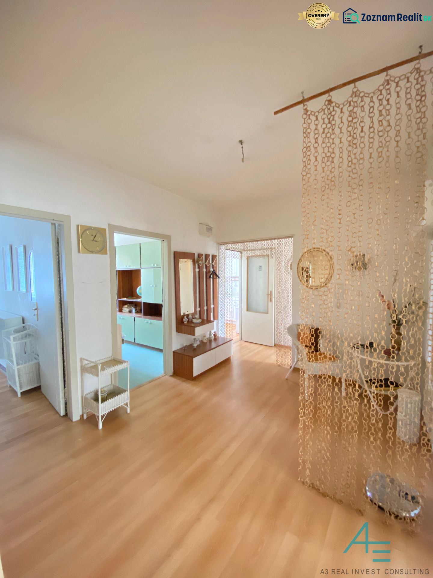 Interior of a 4-room apartment with a wood-patterned floor and a chain curtain.