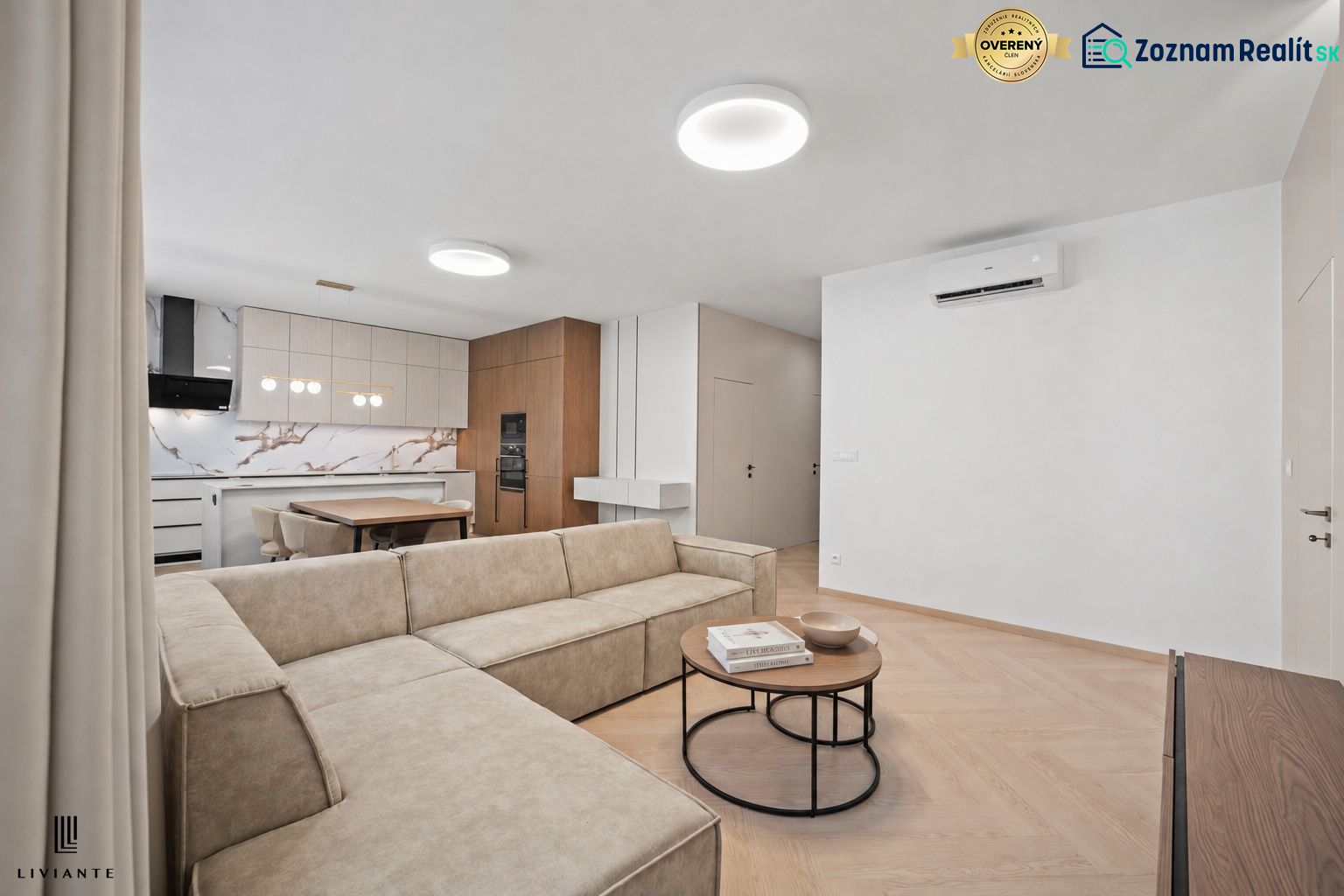 Living room with kitchen in a 4-room apartment, seating, wooden decor flooring, and lighting fixtures.
