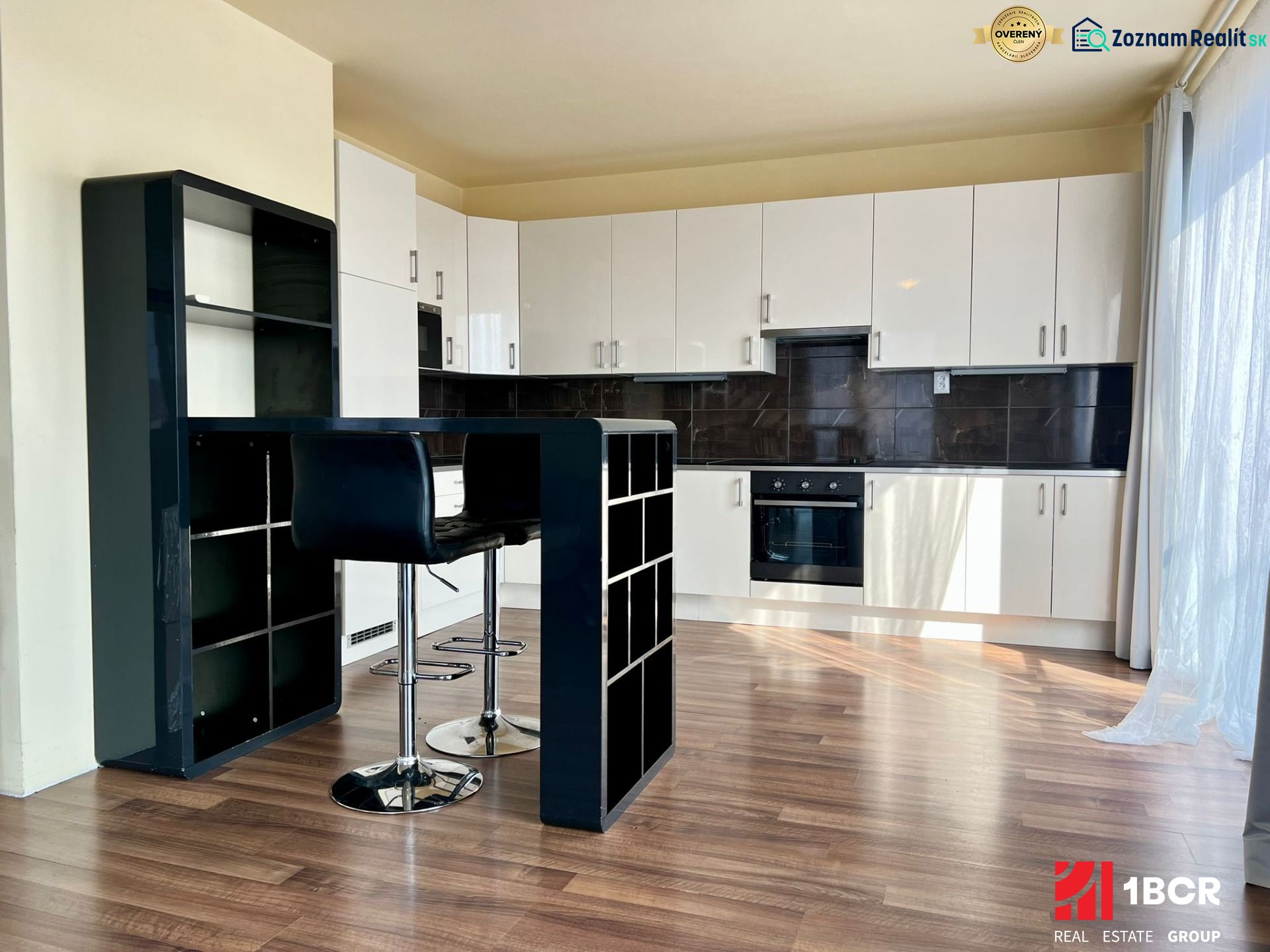 A kitchen corner with a bar and a wooden decor floor in a 2-room apartment.