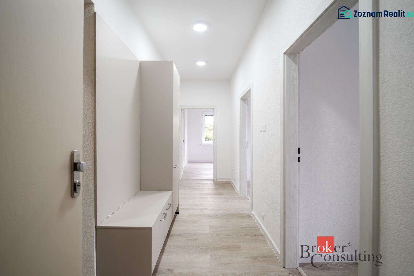 A bright hallway in a 3-room apartment with wood-patterned flooring and furniture.