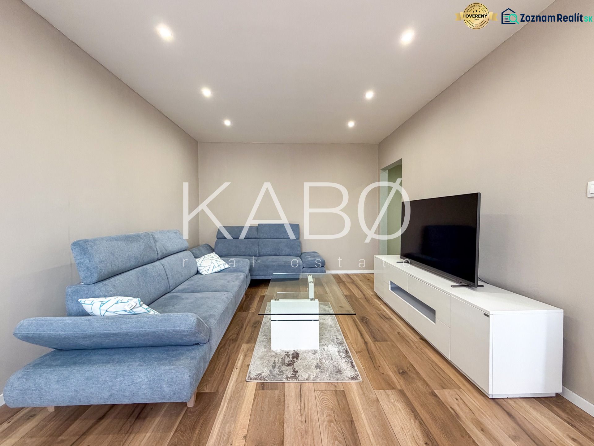 Living room in a two-room apartment with a wooden decor floor and modern furniture.